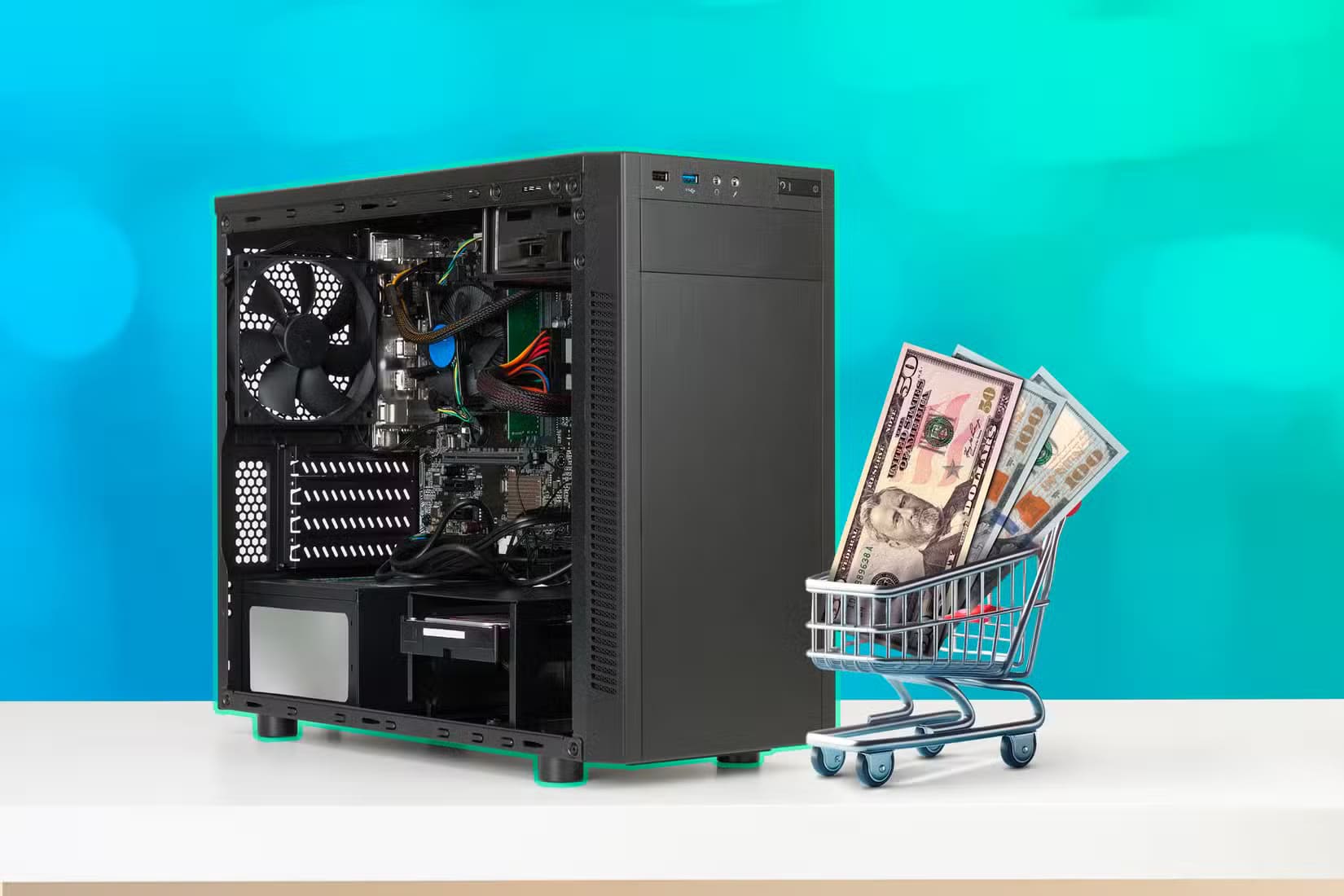 a-computer-case-and-a-miniature-shopping-cart-with-some-dollar-bills-1 لماذا لم تعد أجهزة الكمبيوتر للألعاب خيارًا اقتصاديًا مقارنة بأجهزة الألعاب المنزلية