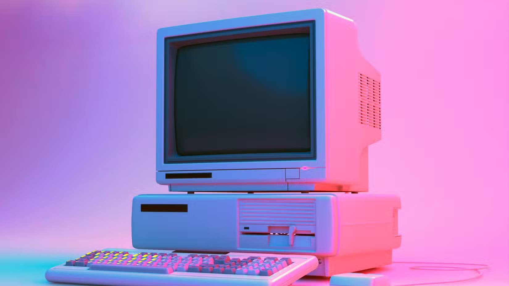 vintage-desktop-pc-with-floppy-drive-keyboard-and-mouse-in-neon-lightning لماذا لم تعد أجهزة الكمبيوتر للألعاب خيارًا اقتصاديًا مقارنة بأجهزة الألعاب المنزلية