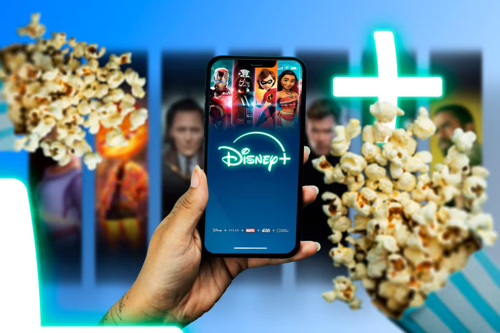 a-hand-holding-a-phone-with-the-disney-screen-displayed-and-two-popcorn-bags-next-to-it مقارنة بين خطط الهاتف المدفوعة مسبقًا وخطط الدفع الآجل أيهما أفضل لاحتياجاتك