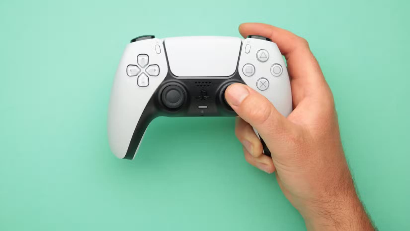 man-holding-dualsense-wireless-controller-with-one-hand ميزات خفية في أجهزة ماك تجعل تجربة الألعاب أكثر متعة وفعالية