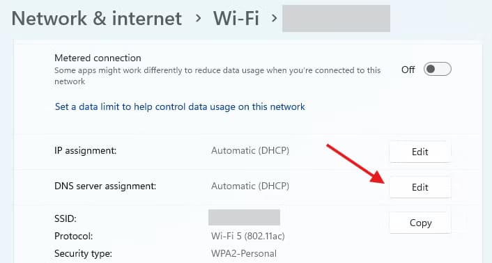 the-wifi-settings-menu-on-windows-11-with-a-red-arrow-pointed-to-the-edit-button-for-dns-server-assignment إعدادات Windows 11 التي يجب تعطيلها فورًا بعد إعادة ضبط النظام لتحسين الأداء