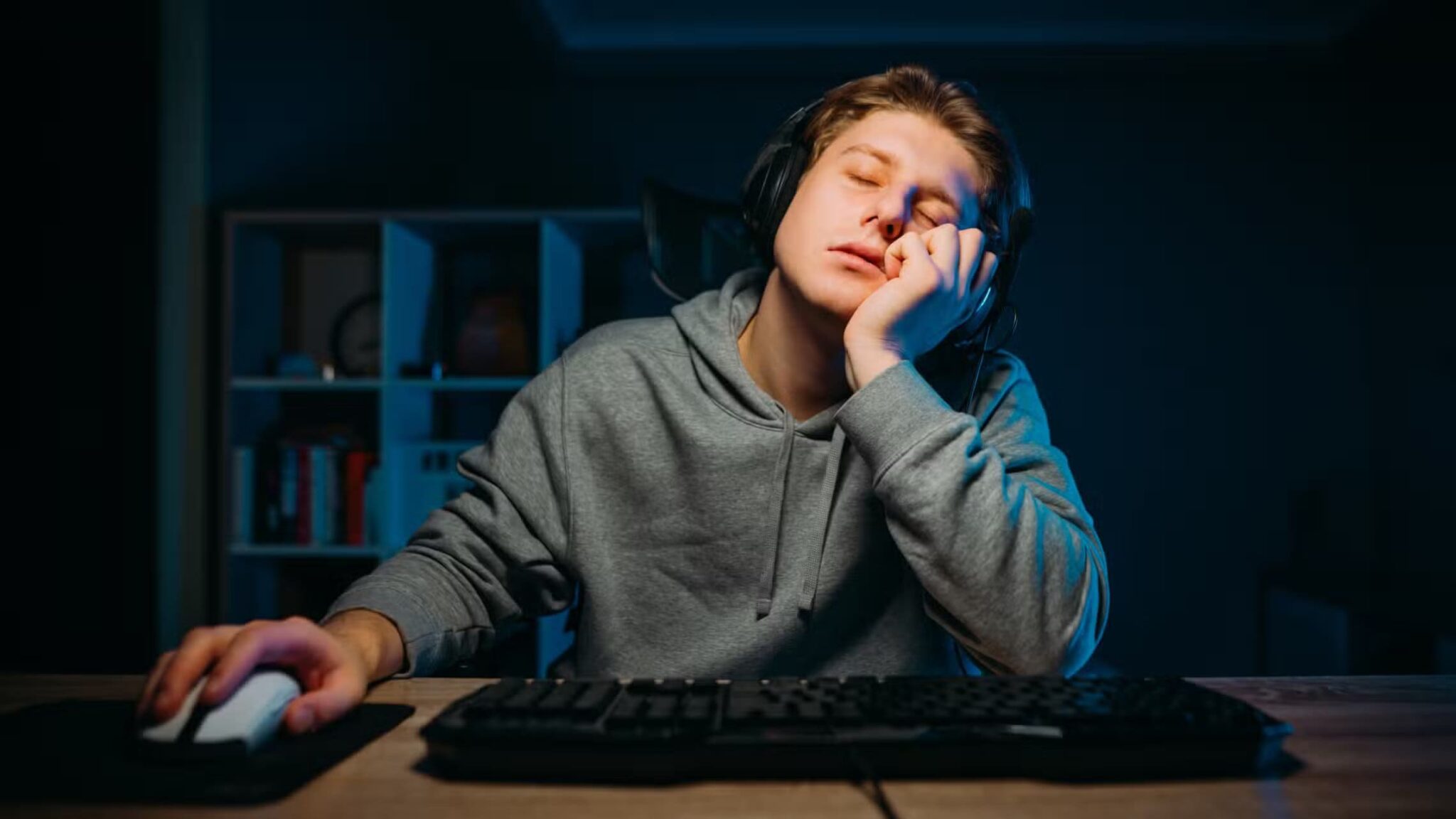 a-bored-and-sleepy-gamer-sitting-at-their-desk-scaled كيف تمنع الإرهاق الذهني خلال جلسات الألعاب الطويلة
